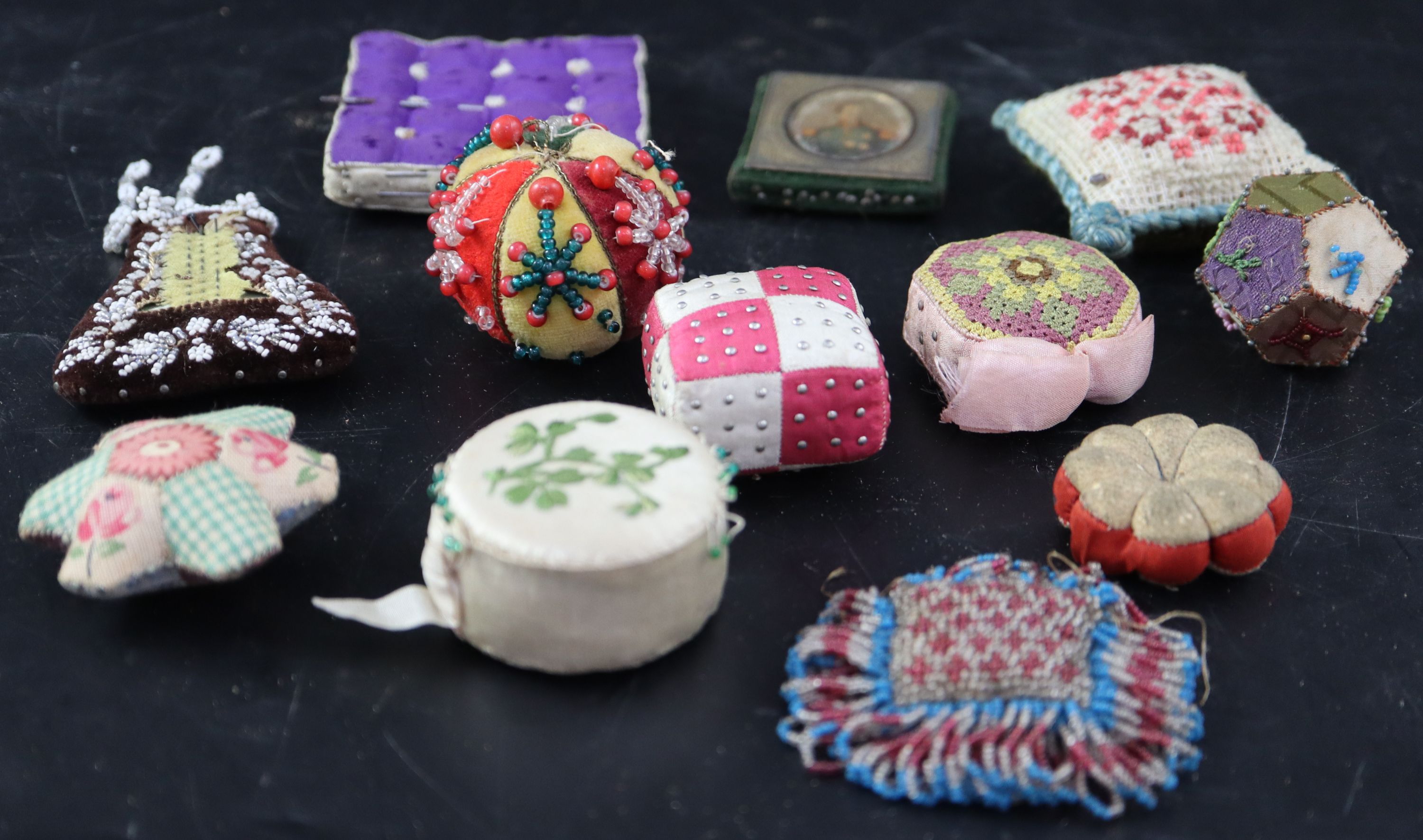 Twelve assorted 19th century fabric pin cushions